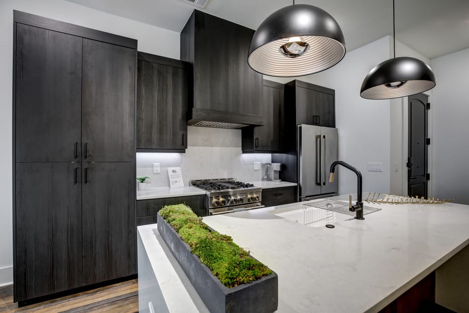 Modern kitchen details w/ gas range, marble backsplash & stainless appliances