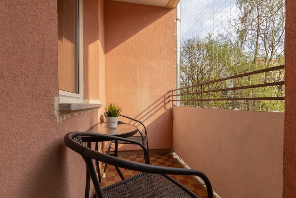 A private balcony with a small table and chairs, perfect for enjoying coffee or tea outdoors.

