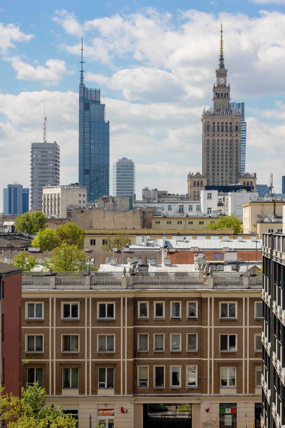 Multiple angles showcasing the vibrant city views and rooftops from the apartment windows and balcony.