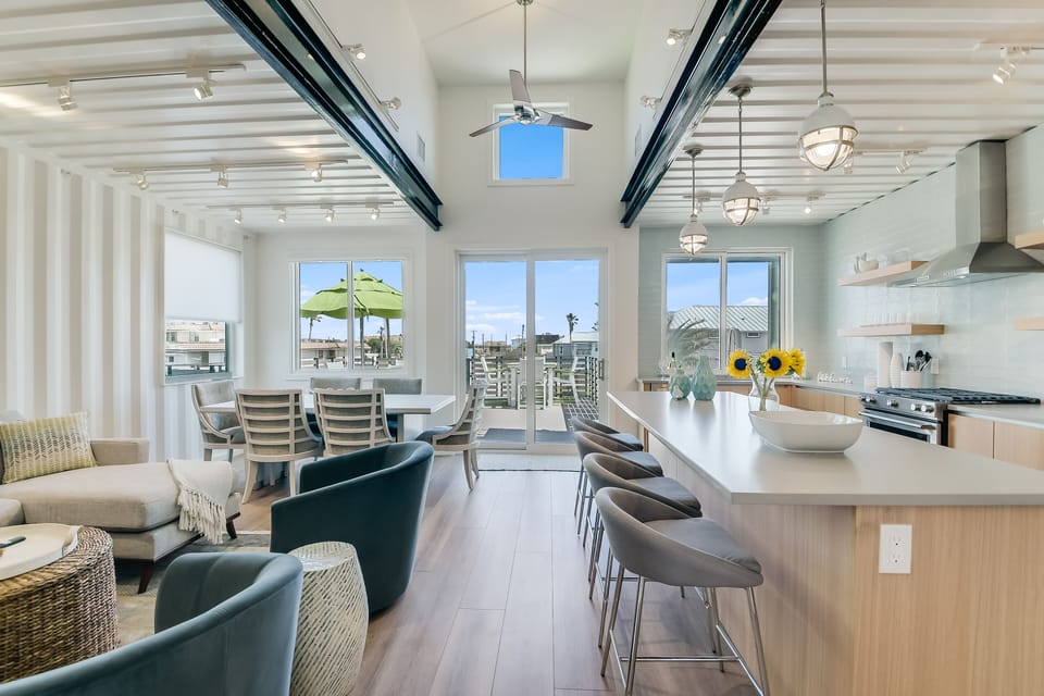 Your bright, airy living space flows seamlessly from kitchen to dining, with stunning natural light streaming through large windows.