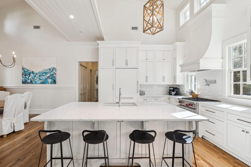 Your gourmet kitchen features pristine white cabinetry, marble countertops, and modern appliances perfect for creating memorable meals together.