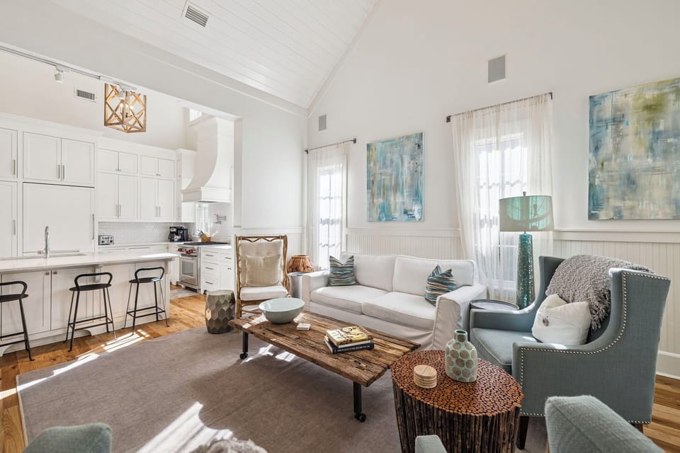Unwind in your bright, airy living space featuring soaring ceilings, a cozy seating area, and a modern kitchen perfect for morning coffee.