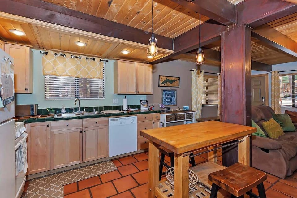 Kitchen with high top table, dishwasher, full size range, and useable countertop space. 