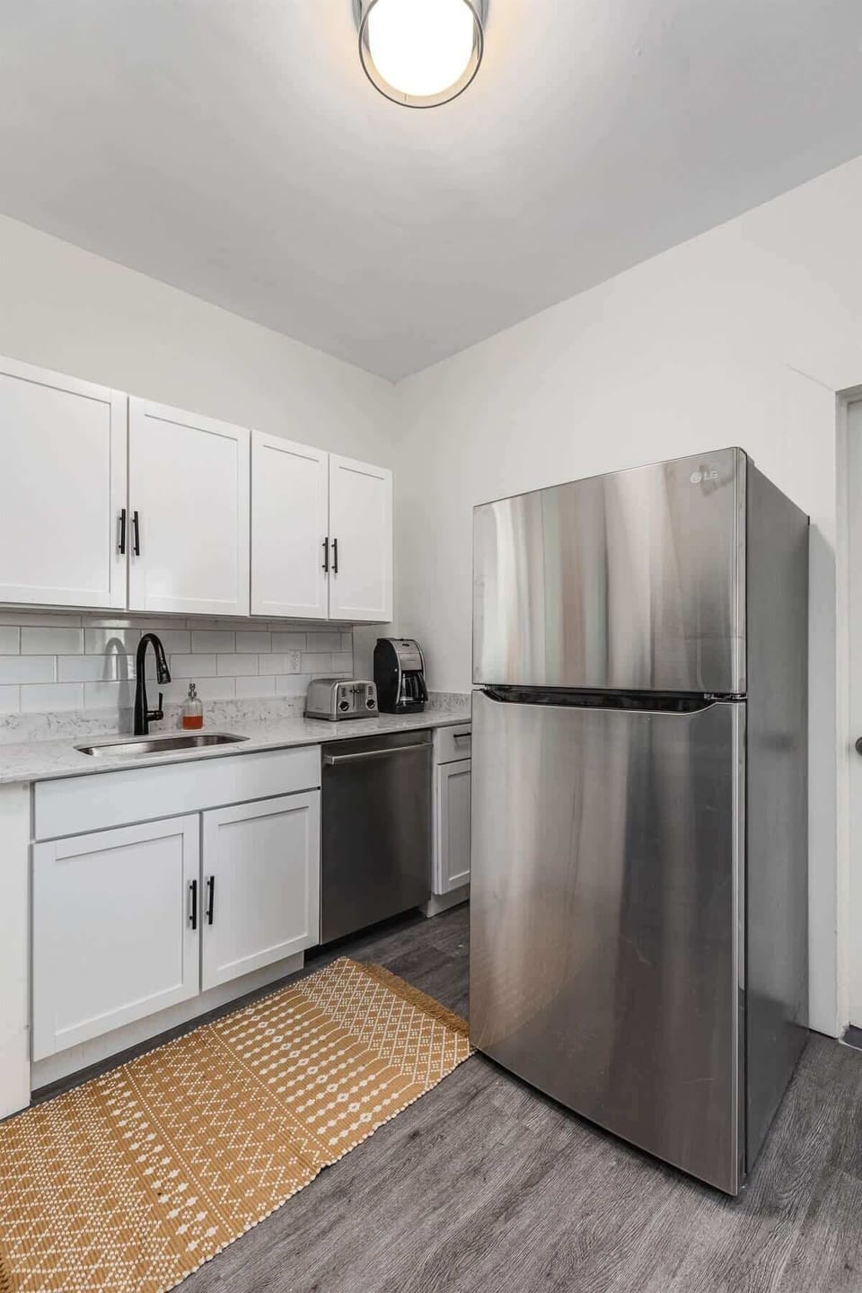 Kitchen with stainless steel fridge and ample storage.