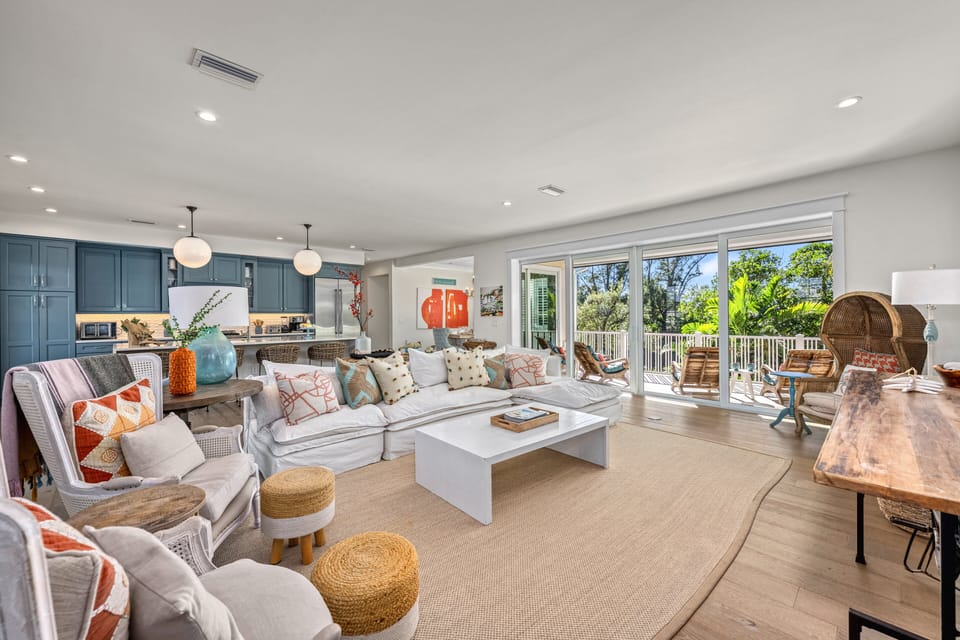 Sunlight fills the open layout, blending kitchen, living area, and balcony for effortless island living.