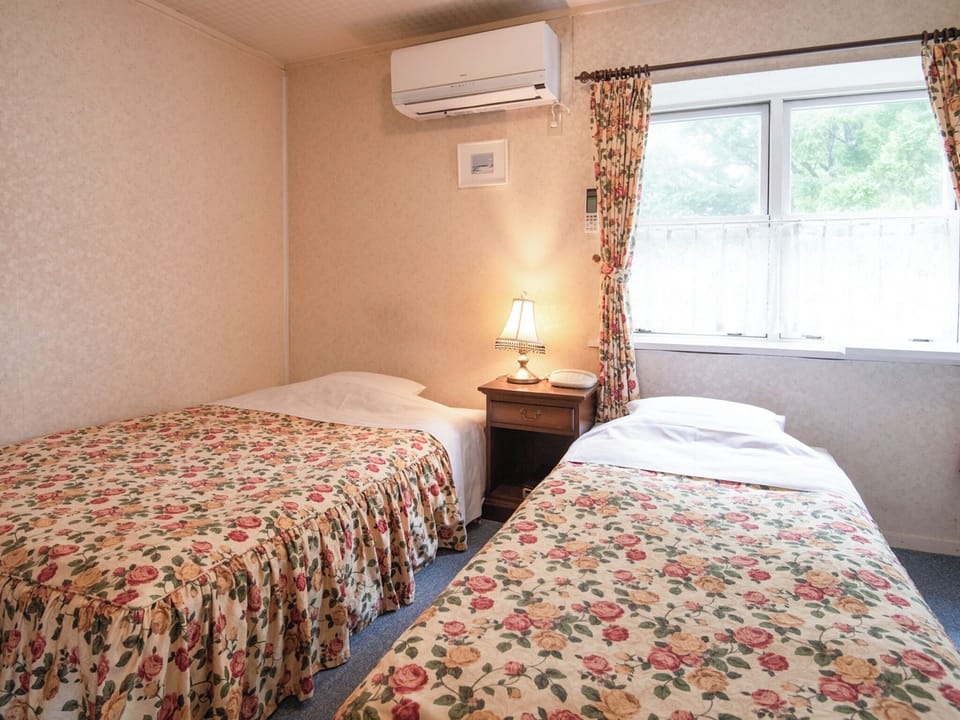 ・[Main building 202: Bedroom] The rose bedspread creates an elegant atmosphere.