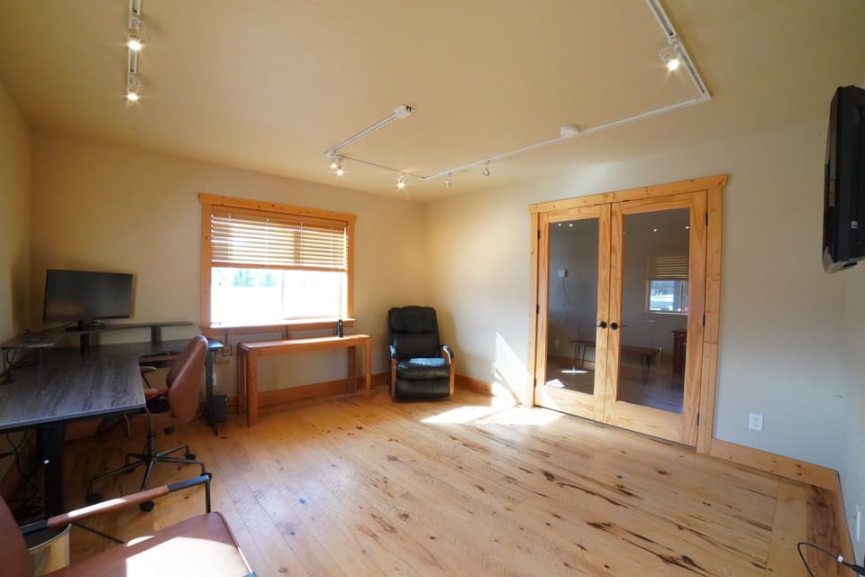 Just off the entryway is a dedicated workspace with a computer monitor and a television.