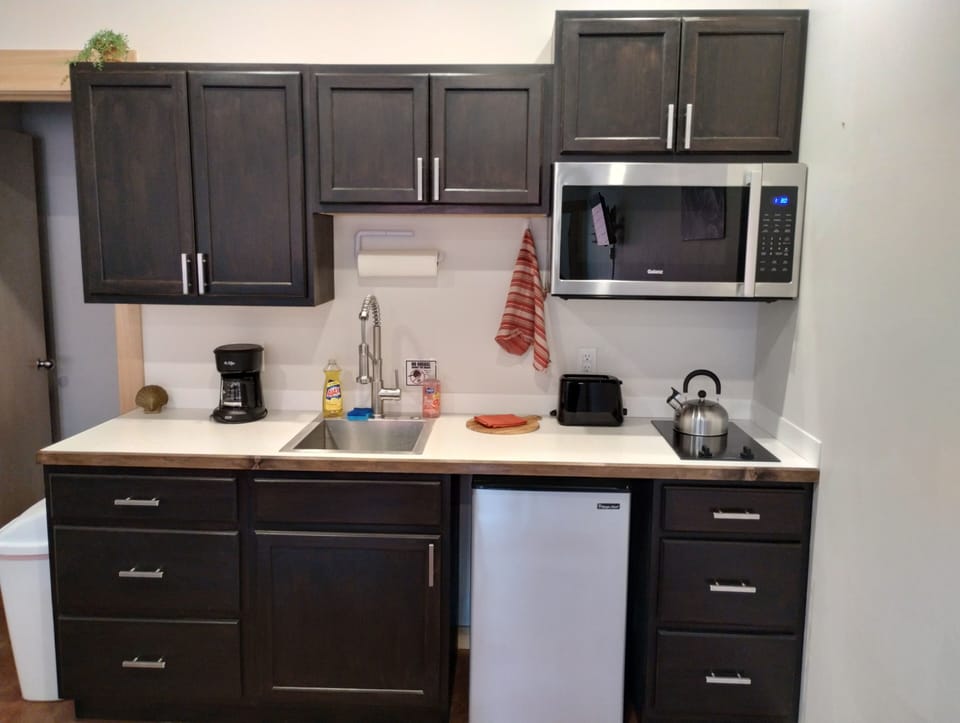 Grewingk Suite. Kitchen equipped with cooking essentials including  4-Cup Drip Coffee Maker. Filters, coffee, creamer packets, and sugar provided.