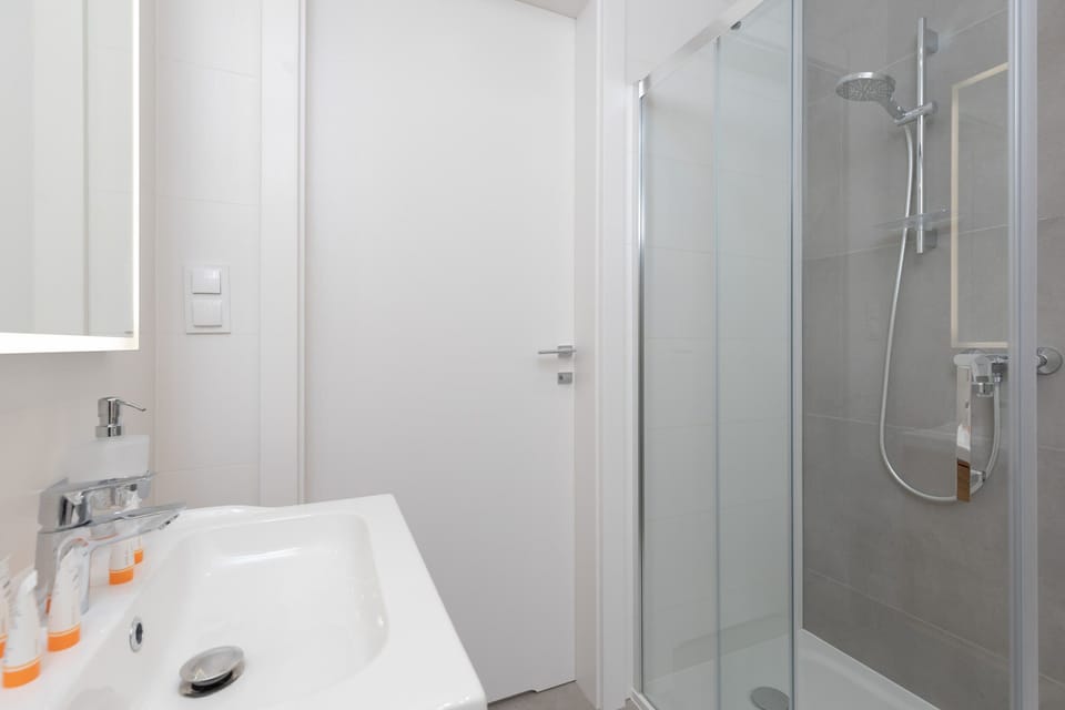 Bright bathroom with washing machine and shower cabin. 