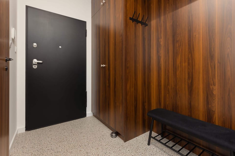 Entryway with wooden paneling, a secure door, and a bench for added convenience and style.
