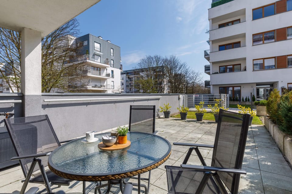 An outdoor terrace with a table and chairs, ideal for enjoying meals or relaxing outdoors.