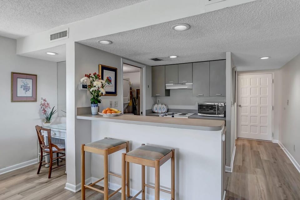 - Enjoy morning coffee or casual meals at this sleek breakfast bar with cozy seating for two
- Modern finishes, recessed lighting, and wood floors give this space a polished vibe
- Conveniently positioned between kitchen and living area