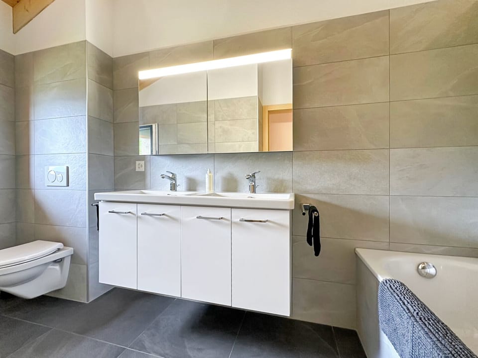 New shower room with WC, double washbasins and bath.