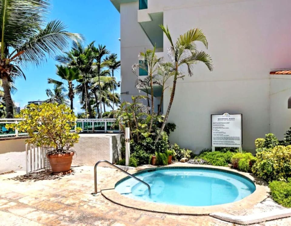 Outdoor whirlpool surrounded by tropical plants and sunny skies