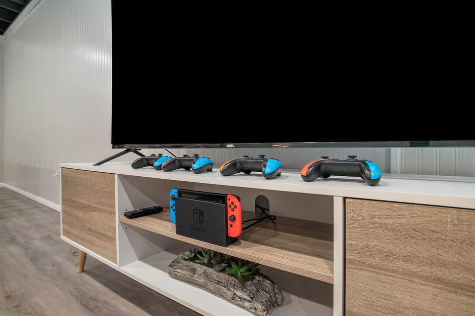 Get ready for some serious gaming fun! Four Nintendo Switch controllers and a large TV await you in the game room.