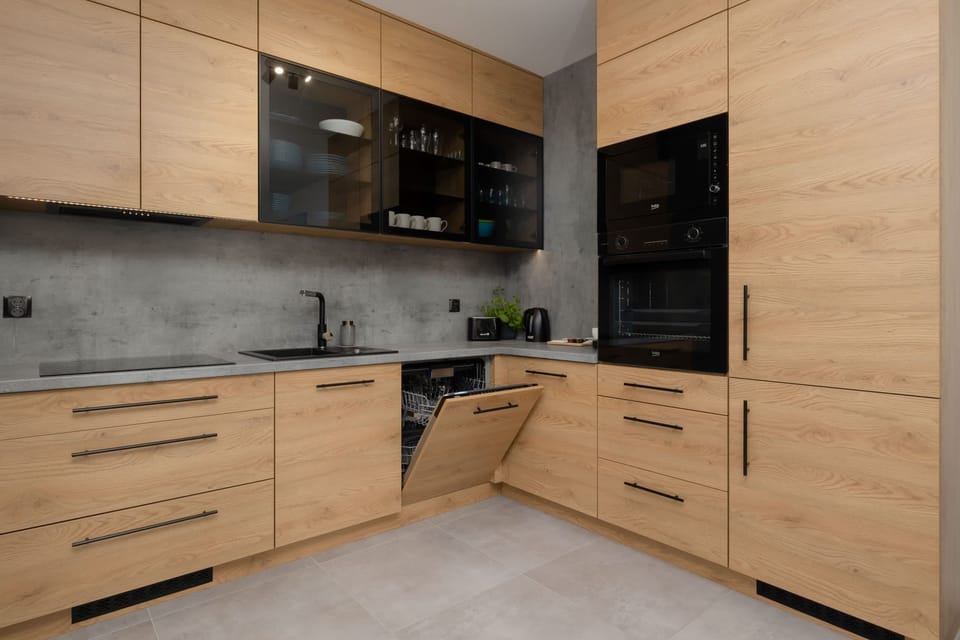 Large kitchen with wooden cabinet fronts and modern wall finishes.
