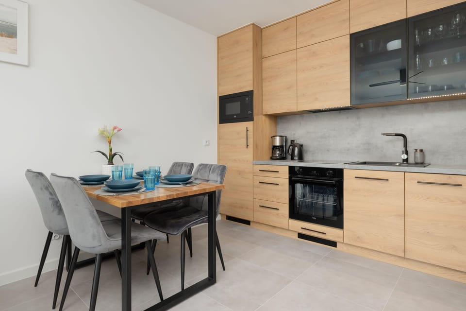 A well-equipped kitchen and dining area, blending modern wood finishes with practical furnishings.

