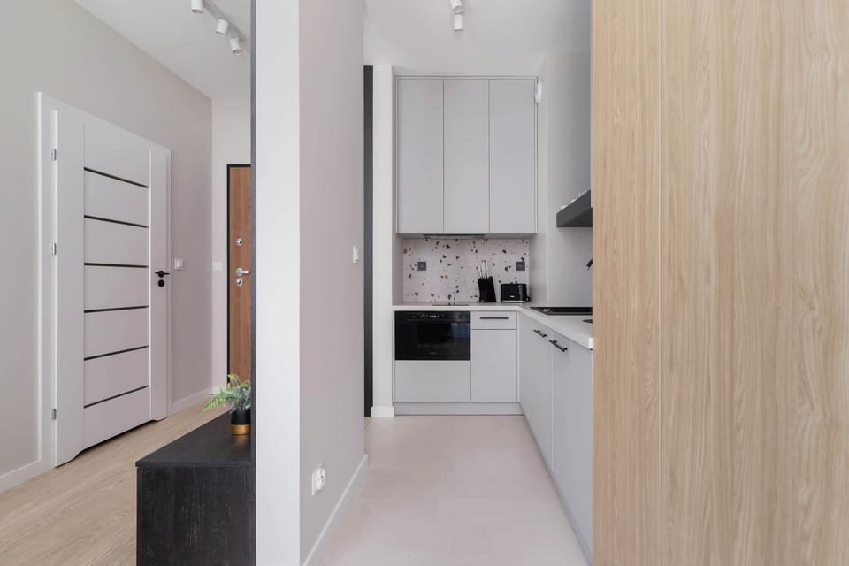 A modern hallway leading to the kitchen and living areas, emphasizing the apartment’s sleek and functional layout.
