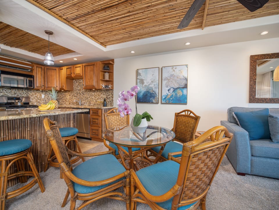 Glass-top dining table with seating for four, framed by bamboo accents.