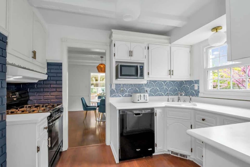 Clean and fully stocked kitchen leading into breakfast nook.