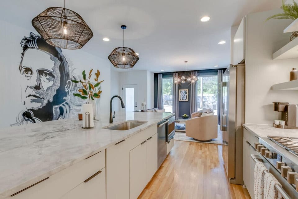 Designer kitchen with an island, pendant lighting, and a bold statement mural