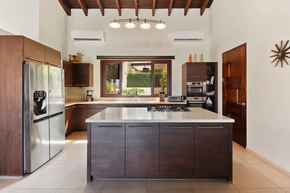 This is a very well-equipped kitchen with all wooden cabinets, a dishwasher, and Corian® Quartz countertops.
