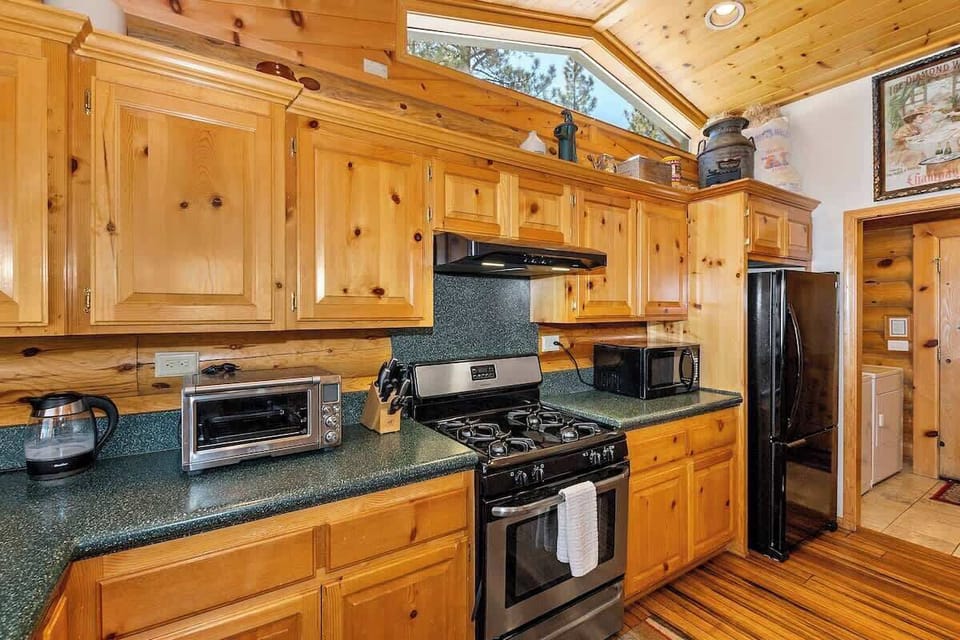 Kitchen with full range, microwave, toaster oven, refrigerator/freezer, entrance to laundry room. 