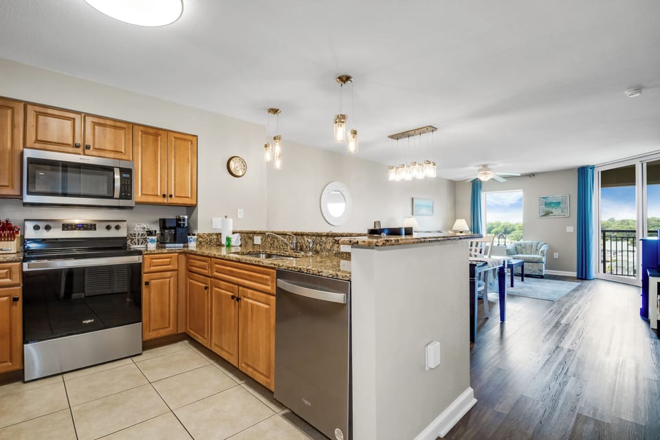 Your fully-equipped kitchen opens to a bright living space where you can cook, dine, and relax with scenic views.