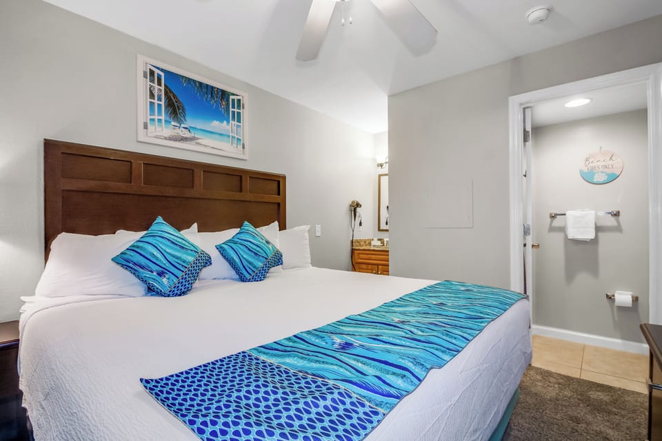 Your coastal bedroom features a plush king bed with ocean-inspired linens, while tropical breezes from the ceiling fan create your perfect sleep sanctuary.