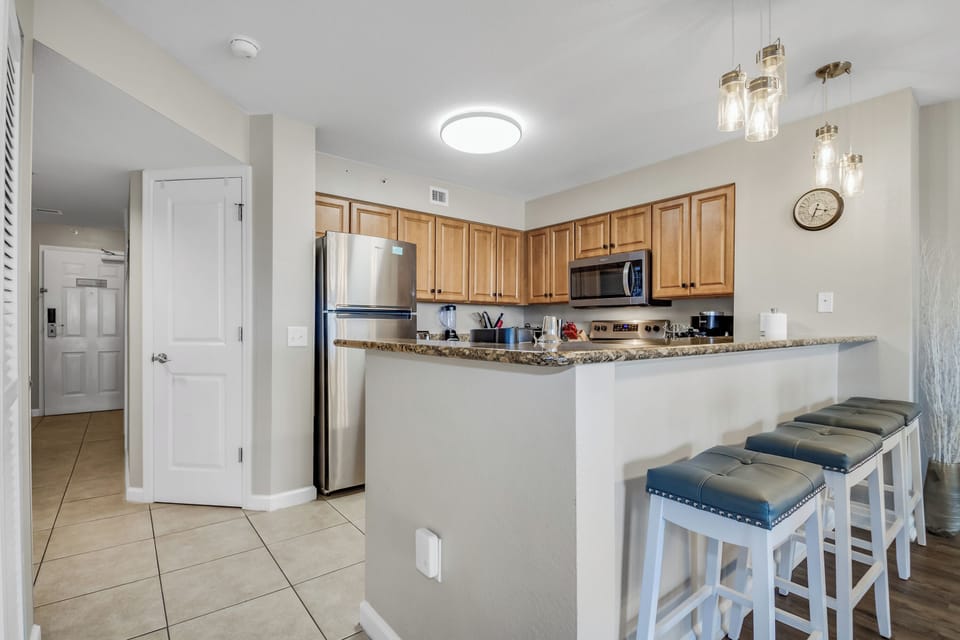 Your fully equipped kitchen awaits with granite counters, stainless appliances, and a breakfast bar perfect for morning coffee or casual meals.