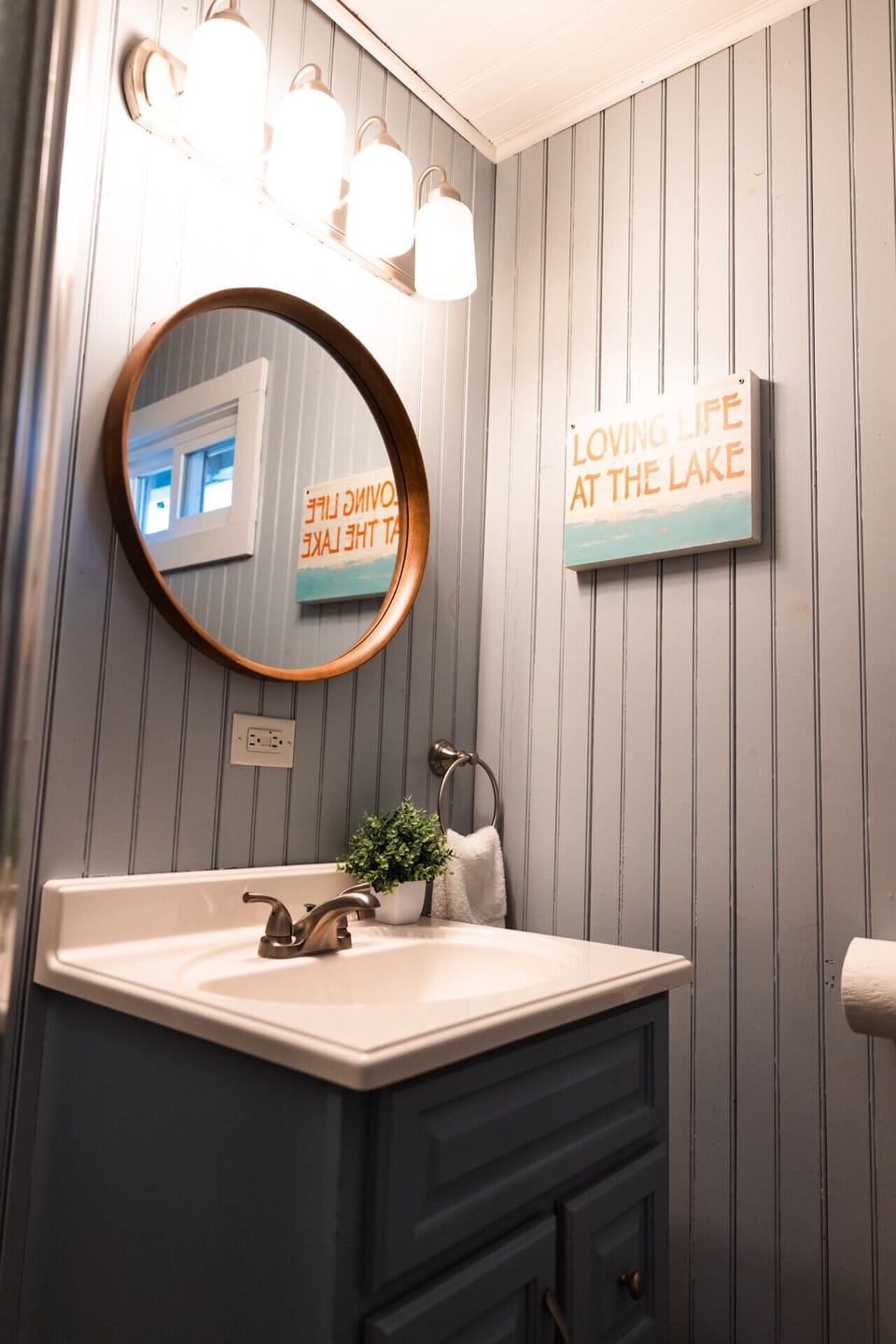 Brushed nickel and beadboard give the bathroom a polished cabin-chic feel.