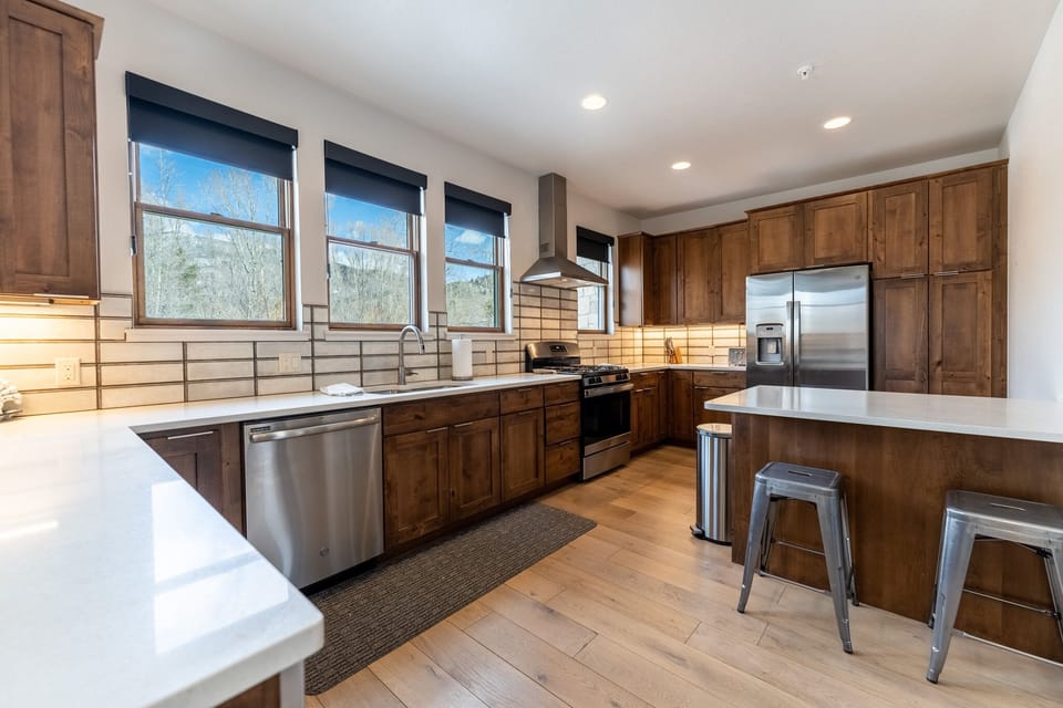 Your gourmet kitchen features rich wood cabinetry, stainless steel appliances, and a spacious island perfect for cooking memorable meals.