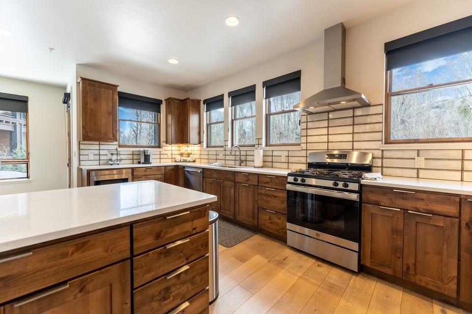 Your gourmet kitchen features warm wood cabinetry, gleaming countertops, and professional-grade appliances perfect for creating memorable meals during your stay.