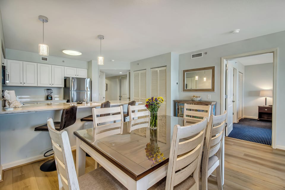 Your open-concept kitchen and dining area invites memorable meals with loved ones, featuring modern appliances and warm coastal colors.