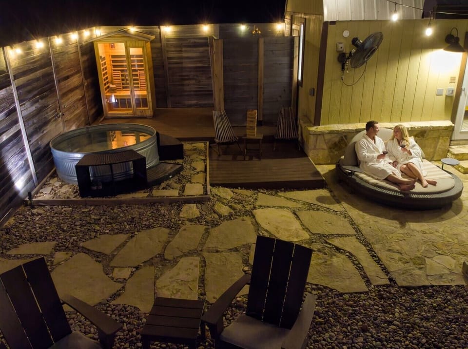 Private wellness circuit at night: infrared sauna, hot/cold plunge pool, and daybed, all inside your fenced spa yard.
