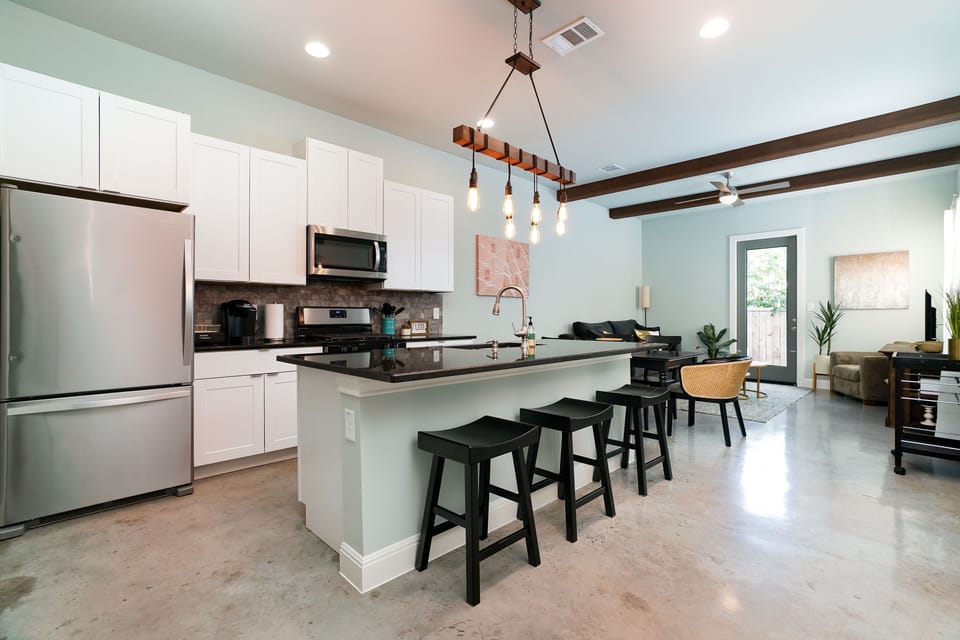 Modern kitchen with large island, sleek appliances, and open layout.