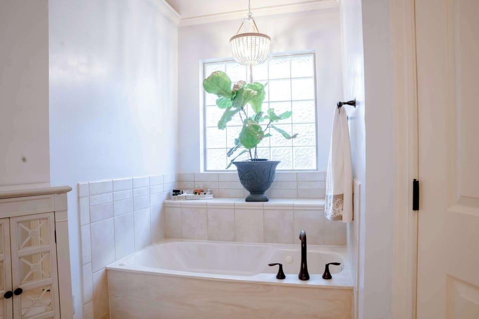 The soaking tub waits under its own little chandelier.