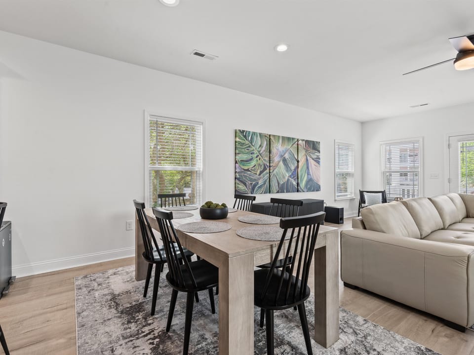 Your stylish dining space flows seamlessly into the living area, featuring a comfortable table for six and cozy seating perfect for memorable meals together.