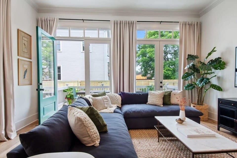 Open concept living area with large sectional and access to outdoor dining area.