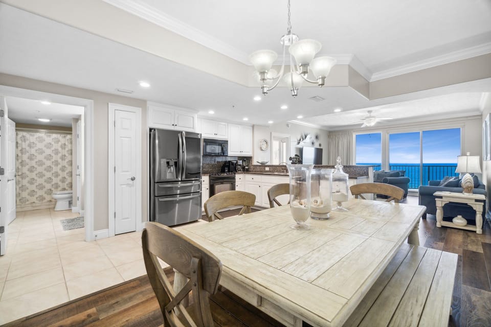 Elegant dining area w/ a marble table, chandelier & seating for the whole group.