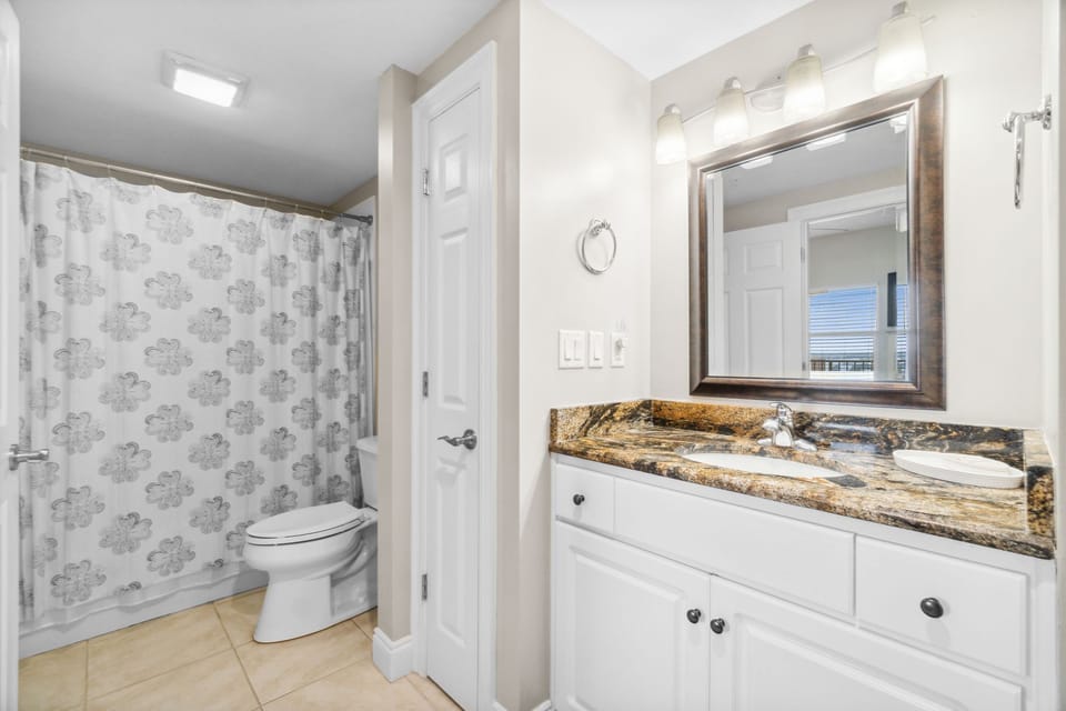 Bright bathroom w/ granite vanity, sink & tub — clean & functional for the whole group.