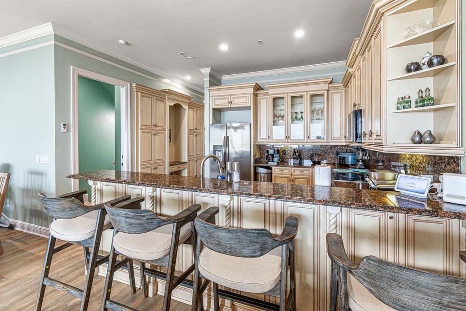 Fully stocked kitchen with island bar and barstools for socializing while prepping your favorite meal!