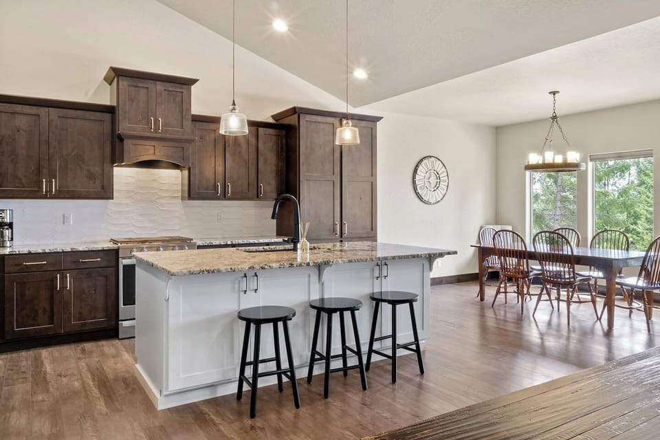 14. Full Kitchen with large kitchen island stocked with three barstools