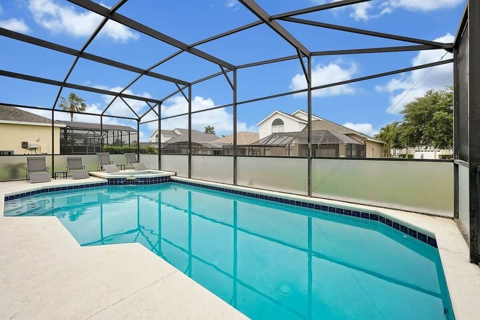 Screened-in private pool with sparkling blue water