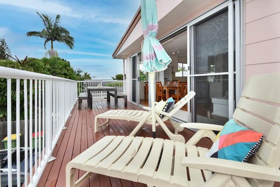 Verandah with dining table and deck chairs