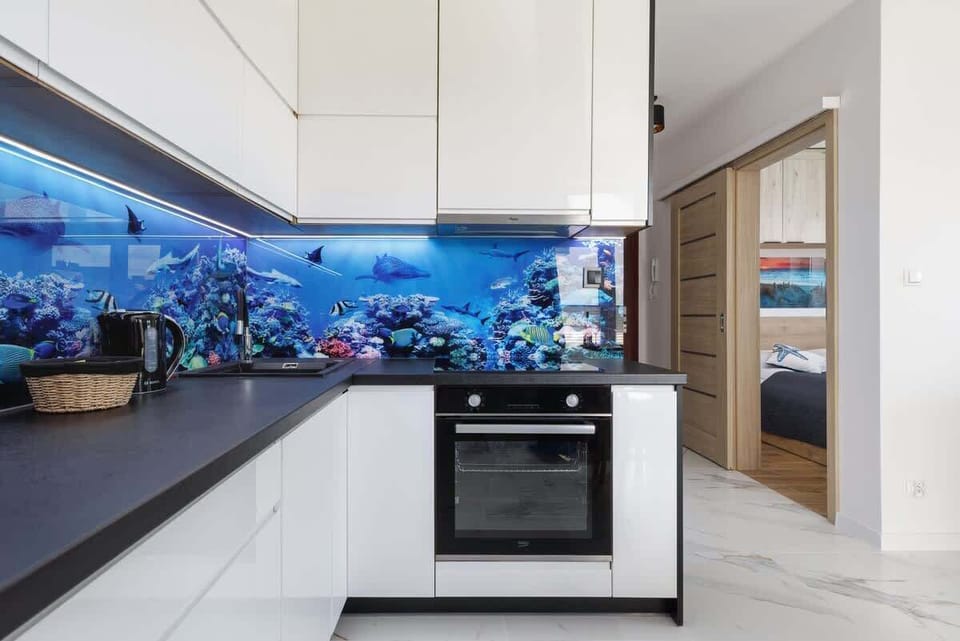 Another perspective of the kitchen, emphasizing its spacious layout and unique aquarium-style backsplash.
