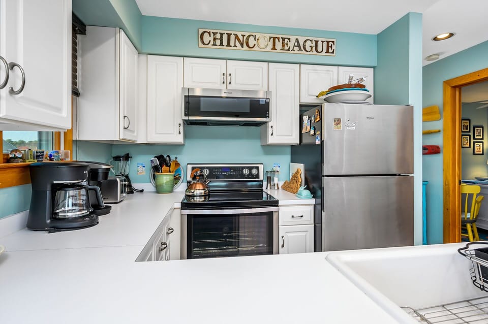 Adorned in Colors of Sea Glass with Stainless Appliances.
