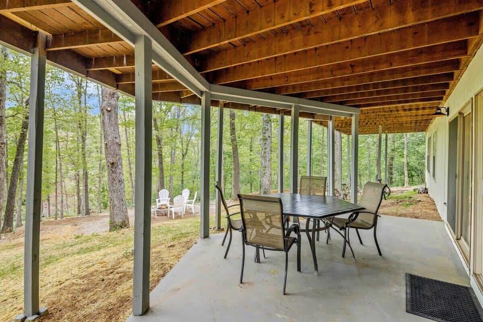 Another outdoor dining table provides additional space for meals under the covered deck
