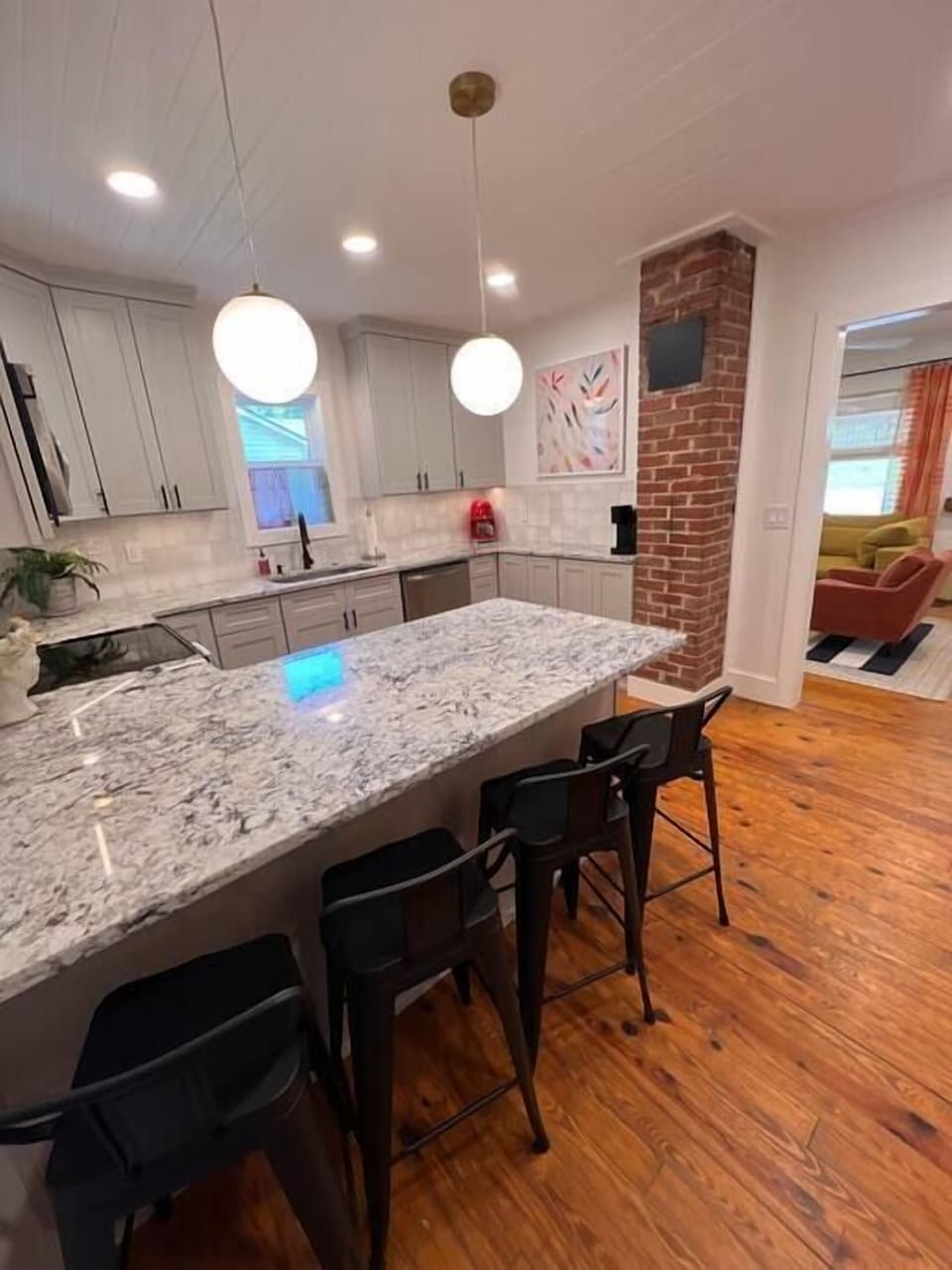 Kitchen has breakfast bar, modern amenities and large sink. 