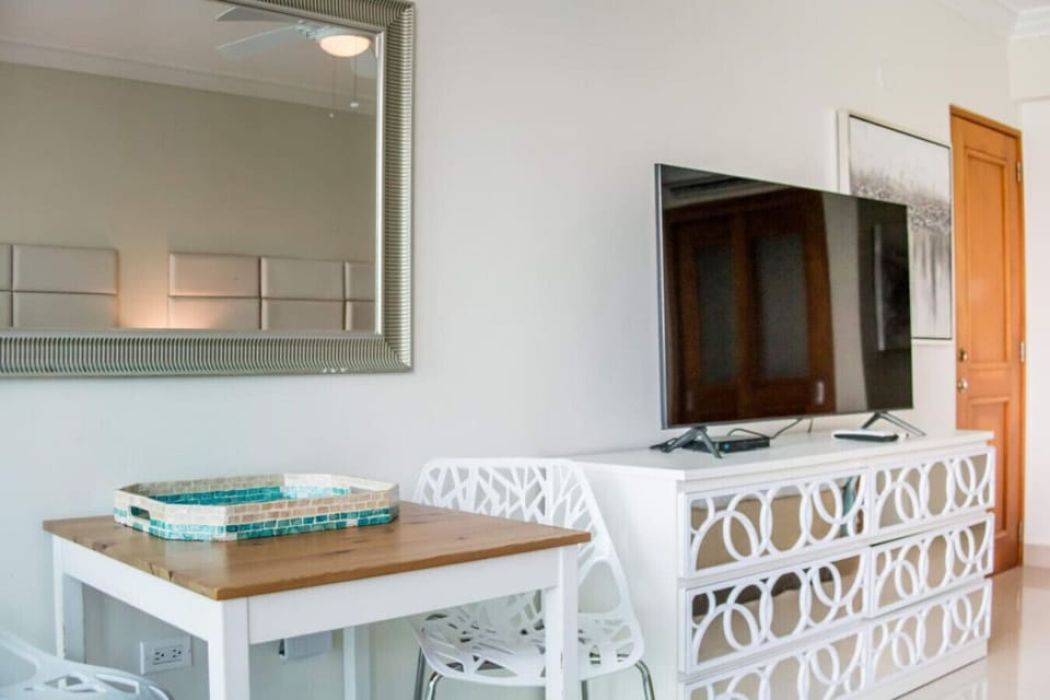 modern living area with a flat-screen tv and decorative mirrored dresser